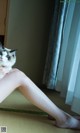 A woman sitting on the floor holding a cat.